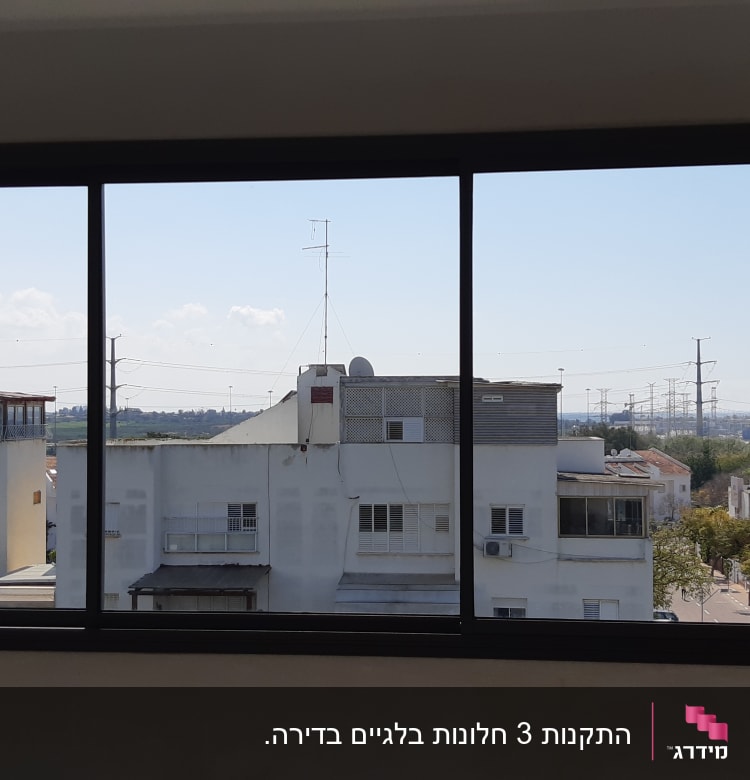 חלון אלומיניום עם נוף עירוני ברקע